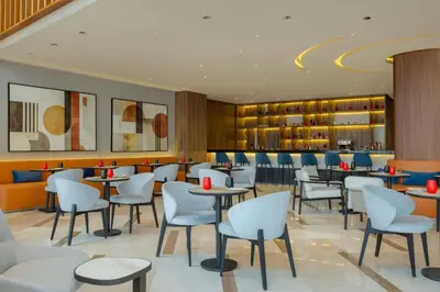 a restaurant with tables and chairs and a bar at Le Meridien Casablanca in Casablanca