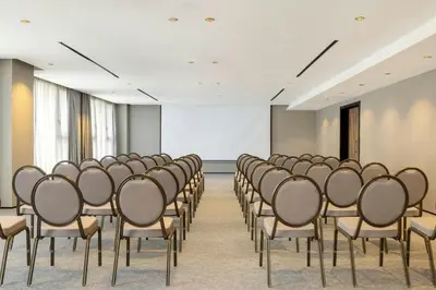 an empty room with chairs and a white screen at Le Meridien Casablanca in Casablanca