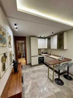 a large kitchen with a wooden table and chairs at Domus Studio - Ambiance Zen au cœur de Casablanca in Casablanca