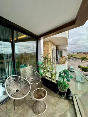 a balcony with two tables and chairs on a building at Domus Studio - Ambiance Zen au cœur de Casablanca in Casablanca