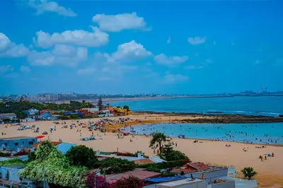 a beach with a bunch of people in the water at Cozy Appartement Relax in Mohammedia