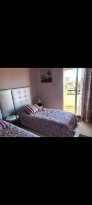a bedroom with two beds and a window at Bahia golf beach bouznika in Bouznika