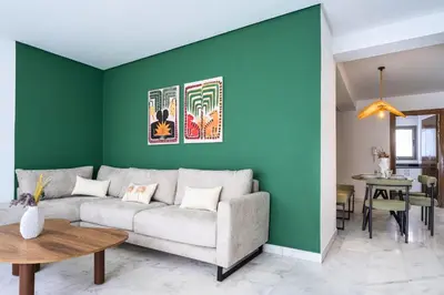 a living room with a couch and a green wall at CASA B l'hôtel in Casablanca