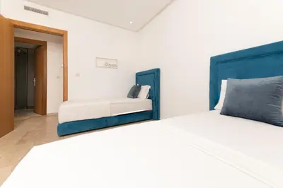 a bedroom with a large bed with a blue headboard at Garden Bay Signature AppartHotel in Casablanca