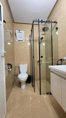 a bathroom with a toilet and a shower and a sink at Charming home in Temara in Temara