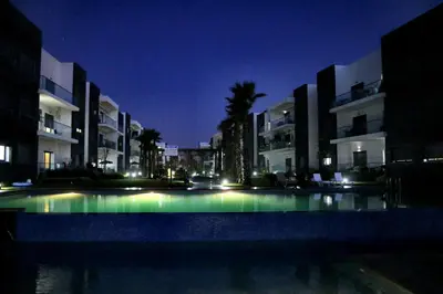 a large pool in front of some buildings at night at Garden Bay Luxe, Tamaris Bord de Mer in Casablanca