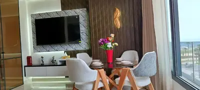 a dining room with a table with chairs and a television at Studio de charme face corniche de Casablanca in Casablanca