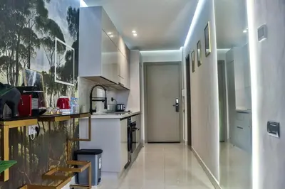a kitchen with white appliances and a hallway at Studio de charme face corniche de Casablanca in Casablanca