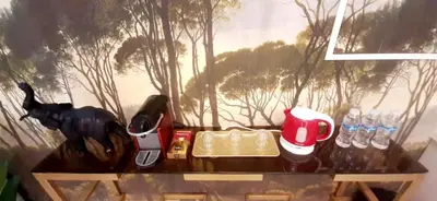 a table with a painting of trees on the wall at Studio de charme face corniche de Casablanca in Casablanca