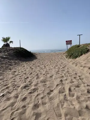 a sandy beach with footprints in the sand at Appartement avec Terrasse, Piscine & Plage à Ola Blanca 2 in Sidi Rahal