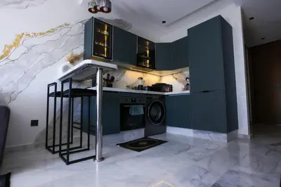 a kitchen with green cabinets and a washing machine at Luxe Ghandi Casablanca in Casablanca