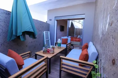 a patio with chairs and a table and a umbrella at Luxe Ghandi Casablanca in Casablanca