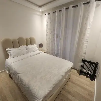 a bedroom with a large white bed with white curtains at Diana Ennour in Rabat