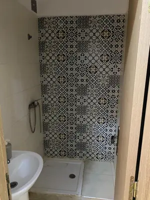 a bathroom with a shower with a toilet and a sink at Appartement à Skhirat in Skhirat