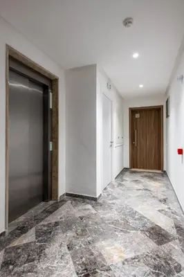 an empty hallway with a door and a tile floor at Chic, bright, 2 BR apartment, panoramic view in Temara
