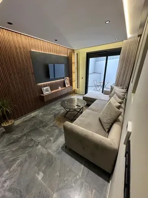 a living room with a couch and a television at Joli appartement a casablanca in Casablanca
