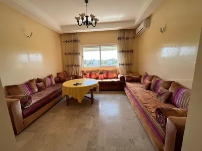 a living room with a couch and a table at Superbe appartement en résidence avec piscine in Mohammedia