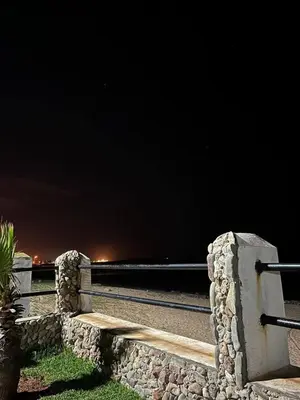 a bench on the side of a road at night at Superbe appartement en résidence avec piscine in Mohammedia