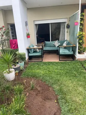 a patio with a green couch on a porch at Casabay T4 Sidi Rahal Vacation apartment in Sidi Rahal
