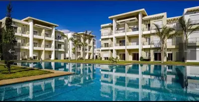 a swimming pool in front of a building at Casabay T4 Sidi Rahal Vacation apartment in Sidi Rahal