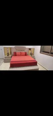 a bedroom with a bed with red sheets and two pillows at Suites au sein d'une Villa au centre ville de Rabat in Rabat