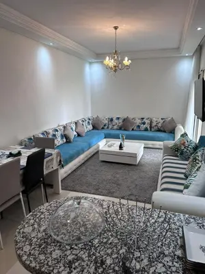 a living room with a blue couch and a table at Studio Seaside Resort Casablanca in Dar Hamida