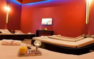 a room with two beds and a red wall at Studio Seaside Resort Casablanca in Dar Hamida