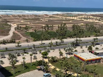 an aerial view of a street with palm trees and the ocean at Zen garden by sea in Aïn Harrouda