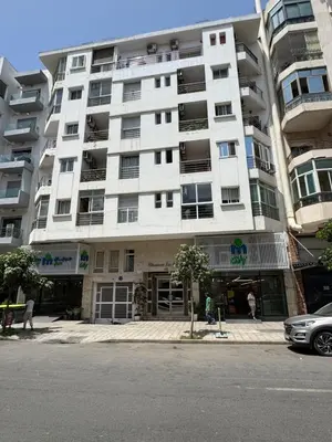a large white apartment building on a city street at BellaVita in Casablanca