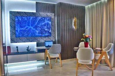 a living room with chairs and a table and a tv at Studio Luxe avec Vue sur la Corniche in Casablanca