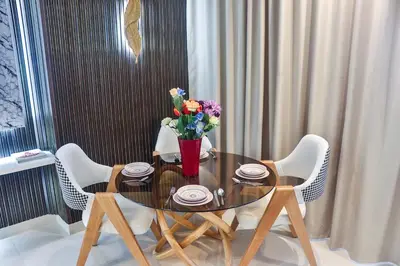 a dining room table with a vase of flowers on it at Studio Luxe avec Vue sur la Corniche in Casablanca