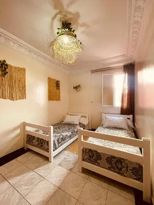 two beds in a room with a chandelier at Beautiful Studio in Casablanca in Casablanca