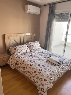 a bedroom with a bed with a comforter and pillows at Appartement fraichement rénové à Agdal in Rabat