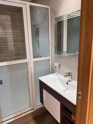 a bathroom with a sink and a shower with a mirror at Appartement fraichement rénové à Agdal in Rabat