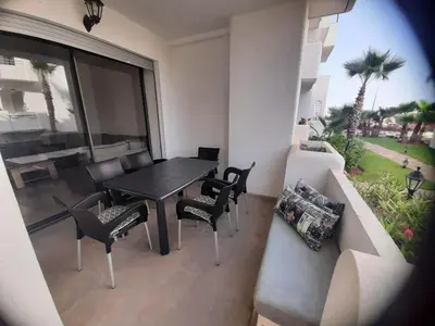 a dining room with a table and chairs and a couch at Mansouria Beach Resort in Mohammedia