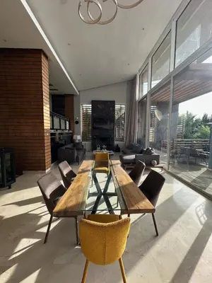 a living room with a wooden table and chairs at 1700sqm Unique Villa in Bouskoura in Bouskoura