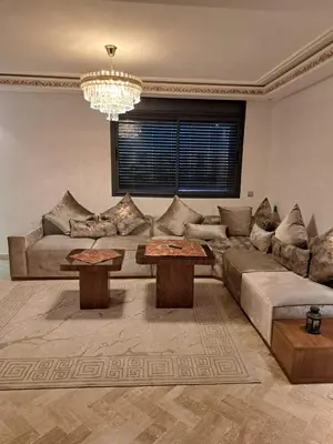 a living room with a couch and two tables at Appartement avec piscine près de la mer in O Ben Slimane