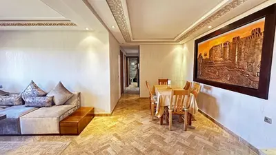 a living room with a couch and a table at Appartement avec piscine près de la mer in O Ben Slimane