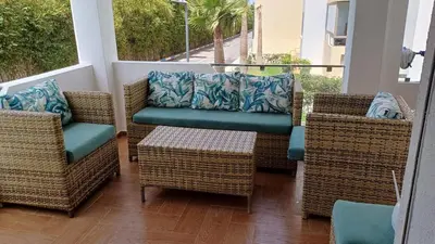 a porch with wicker chairs and a couch and a table at newly and fully furnished apprt in Sidi Rahal