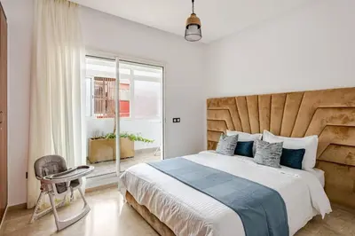 a bedroom with a large bed with a wooden headboard at Luxury Garden View Apartment Private Floor in Casablanca