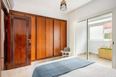 a bedroom with a bed and a wooden cabinet at Luxury Garden View Apartment Private Floor in Casablanca