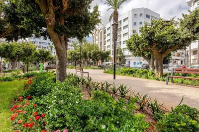 a park with flowers and trees and buildings at Luxury Garden View Apartment Private Floor in Casablanca