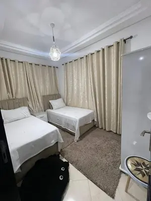 a bedroom with two beds and a window with curtains at Salam Beach in Pont Blondin