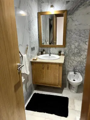 a bathroom with a sink and a toilet and a mirror at Appartement de luxe vue sur mer in Bouznika