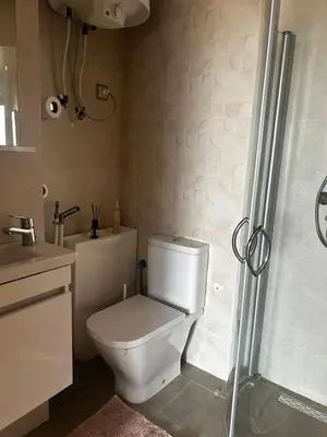 a bathroom with a white toilet and a shower at Sidi Rahal Blue Beach in El Jadida