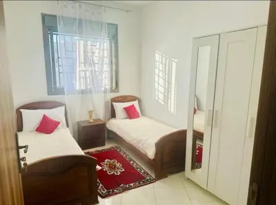 a small room with two beds and a window at A 2min hôpital M6,Proche d'Aéroport et la gare bouskoura in Bouskoura