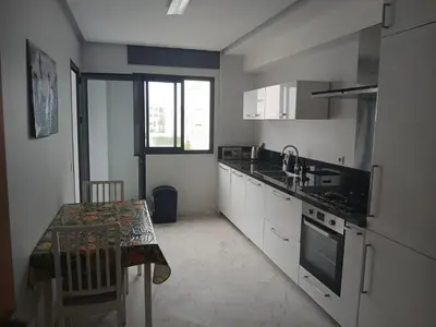 a kitchen with a sink and a stove top oven at Vakantie app charmante Harhoura in Temara