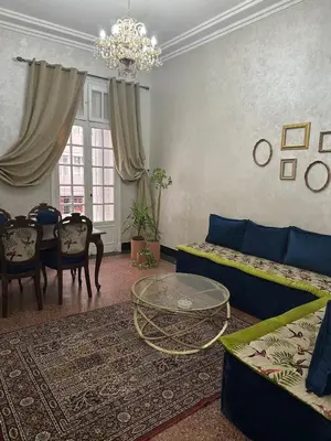a living room with a blue couch and a table at Cosy 2BR in Heart of Casablanca in Casablanca