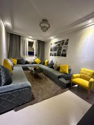 a living room with a blue couch and yellow chairs at Maison à louer à Mohammedia in Mohammedia