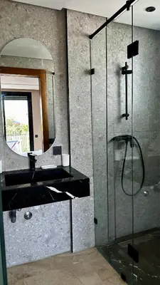 a bathroom with a glass shower and a sink at The Hidden Secret in Casablanca